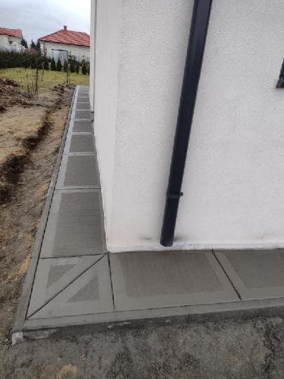 Chodnik betonowy przy narożniku domu z dekoracyjnym wzorem diagonalnym