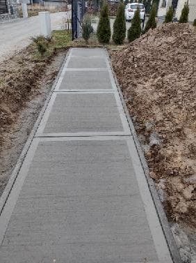 Chodnik betonowy szczotkowany prowadzący do furtki wejściowej